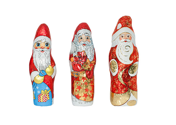 Three decorative chocolate Santa Clauses, each in different designs and colors, stand side by side.