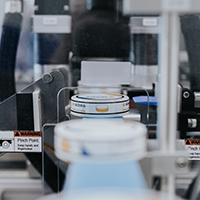 Machines in a production line for filling containers, with a focus on labeling and packaging.