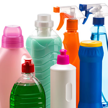 Various bottles of cleaning products in different colors and shapes, including spray bottles and pump bottles.