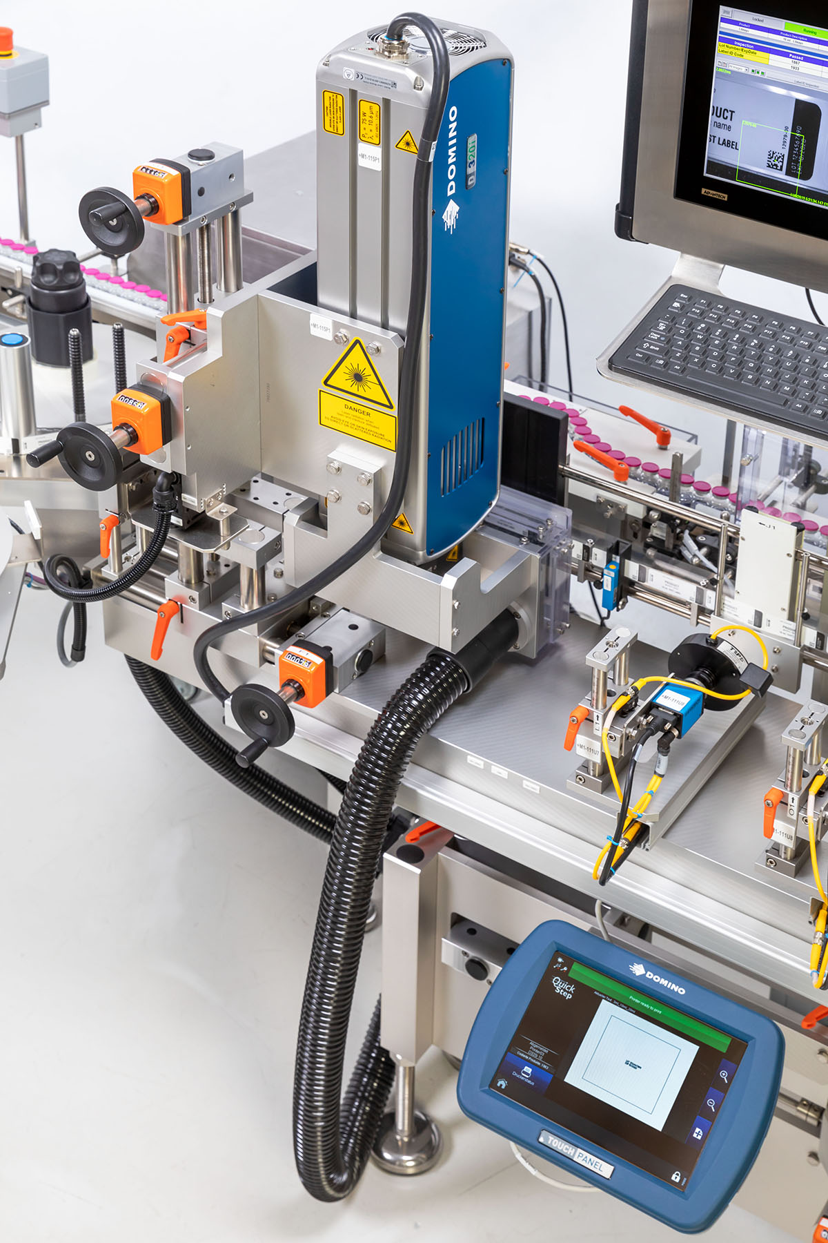 Industrial labeling machine with a print head, control screen, and various connections for labeling and coding.