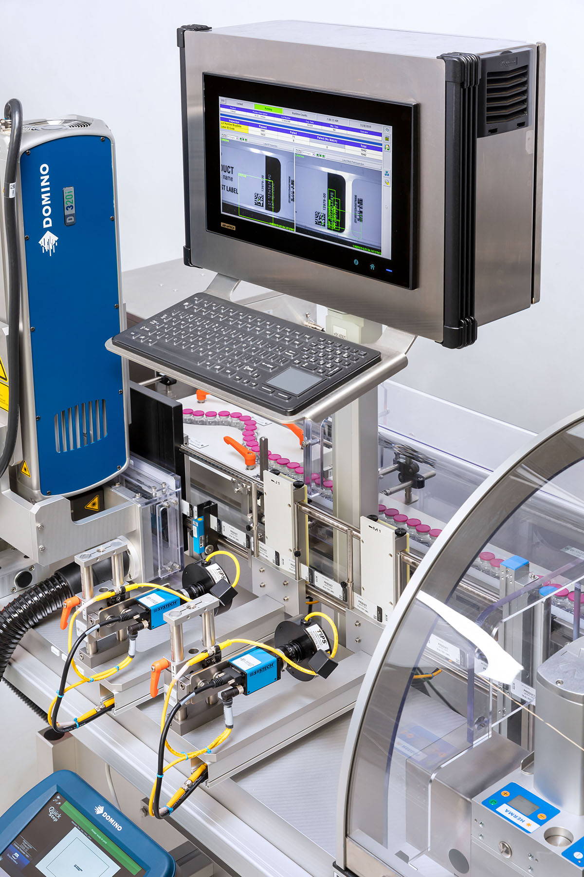 Industrial labeling machine with a screen, keyboard, and various sensors for automated labeling and coding.