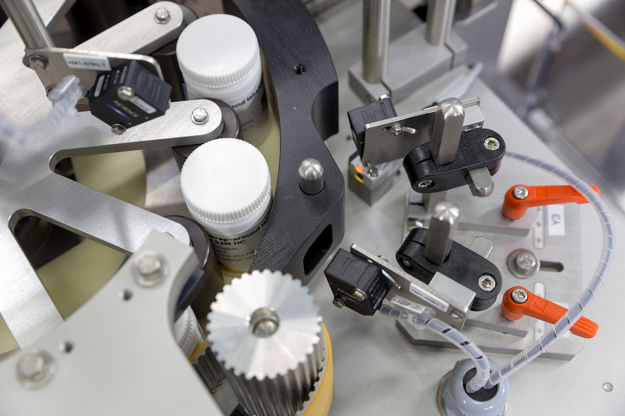 Machine parts for bottling, including sensors and mechanisms for controlling the process.