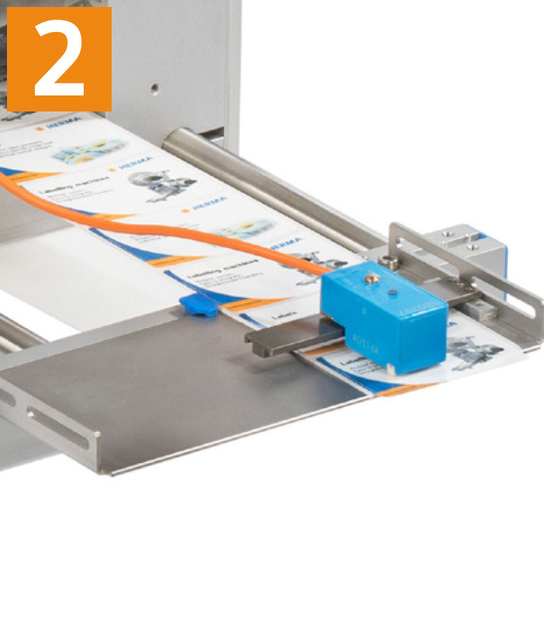 A device for processing materials with a blue control unit and a conveyor belt that transports documents.