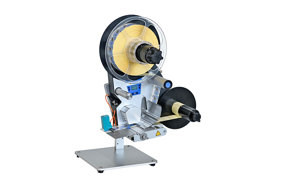 A labeling device with two rollers, a control unit, and a sturdy base, suitable for various labeling applications.
