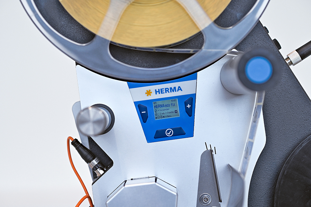 A labeling device with a digital display and a roll of labels. The controls are clearly visible.