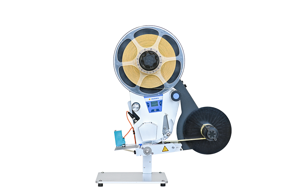 A machine for processing tapes, equipped with a large spool and a control panel for operation.