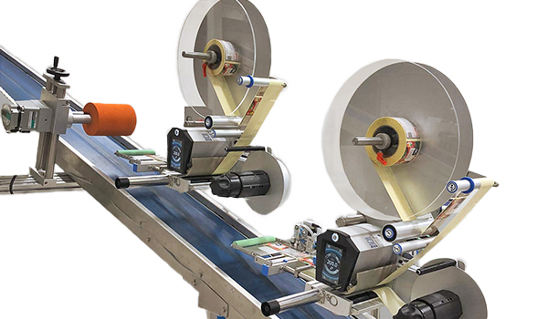 A labeling system with two rollers that applies labels to products. The machine is equipped with motors and control elements.