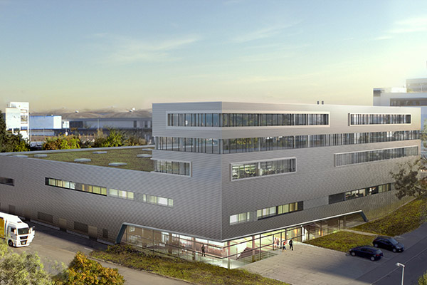 Modern, multi-story buildings with large windows and green roofs, surrounded by an urban environment and vehicles.