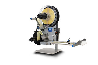 A labeling device with a large spool, a dispenser, and a control unit for applying labels to products.