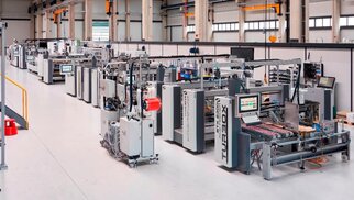 A modern production hall equipped with several machines and facilities designed for the manufacturing and assembly of components.