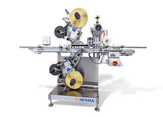 Automatic labeling machine with two labeling heads, equipped with rollers and control elements, mounted on a sturdy frame.