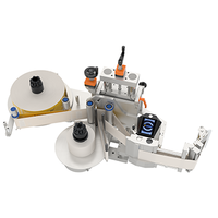 Automatic labeling machine with two rolls, a labeling mechanism, and a control panel for managing the process.