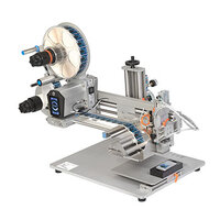 Automatic labeling machine with roll holder, label dispenser, and control unit on a sturdy base.