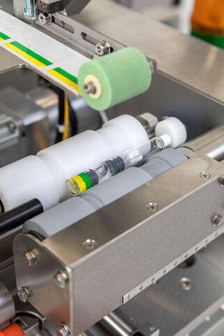 Machine parts arranged in transparent and colored containers within an industrial setting.