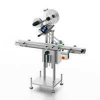 Labeling machine with a conveyor belt and two rolls for labels, equipped with a control panel for operation.