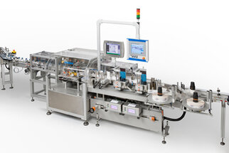 Automated production line with machines for processing and packaging products, equipped with a monitor and control elements.