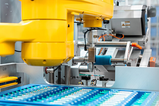 Industrial robots featuring two different models, one on a table and the other at an assembly unit, surrounded by technical graphics.