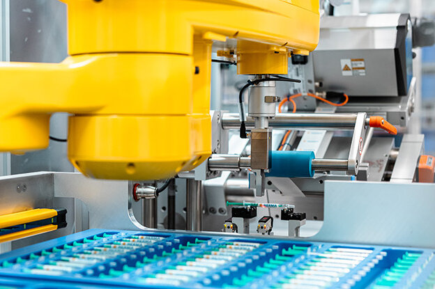 Industrial robots featuring two different models, one on a table and the other at an assembly unit, surrounded by technical graphics.