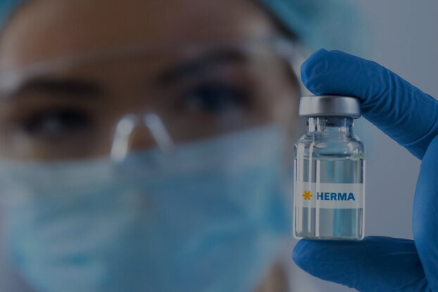 A person in protective gear is holding a vaccine vial labeled 'China'.