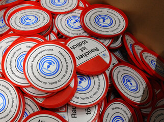 Red and white plaques with the text 'Smoking is deadly' and a symbol, stacked in a box.