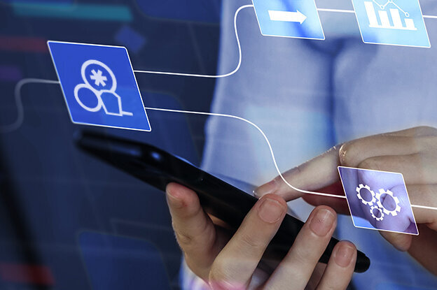 A person is holding a smartphone while digital symbols and diagrams are displayed in the background, representing data and networks.